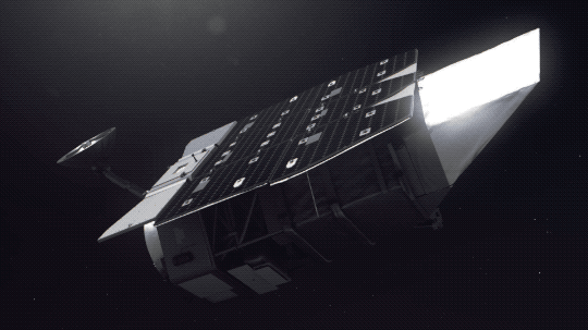This animation shows an artist’s concept of the Nancy Grace Roman Space Telescope against a black backdrop. The telescope is mostly silver and roughly cylindrical, with a shiny rectangle of solar panels on top and a small antenna extending from near one end. As Roman turns, we can see its primary mirror inside, ready to observe the universe.