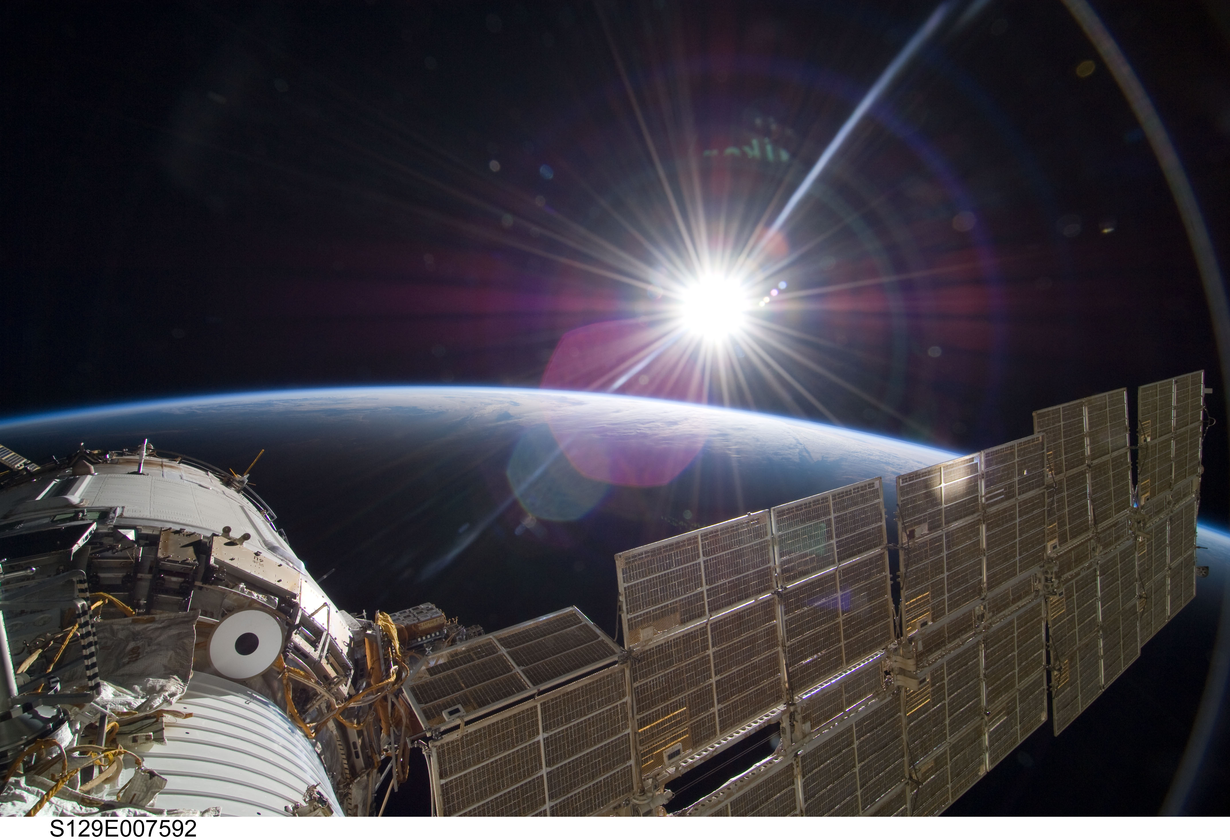 APOD: 2009 November 30 – Bright Sun and Crescent Earth from the Space Station