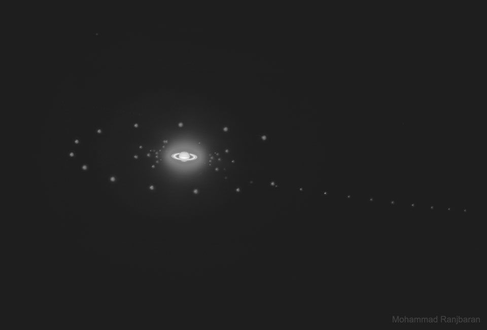 The picture shows the planet Saturn with several of its moons in a multiple exposure. Please see the explanation for more detailed information.