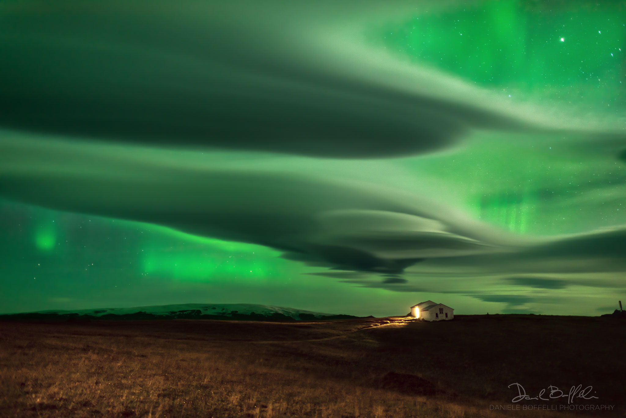 The picture shows green aurora through odd lenticular clouds. Please see the explanation for more detailed information.