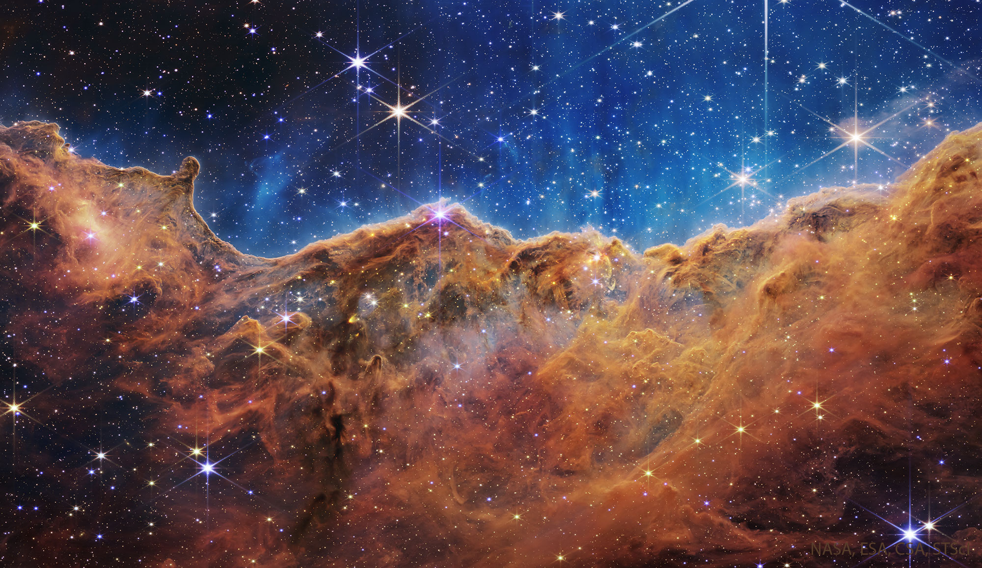 The featured image shows a dense line of dark dust that appears like cliffs in the Carina Nebula as captured by the Webb Space Telescope. Please see the explanation for more detailed information.