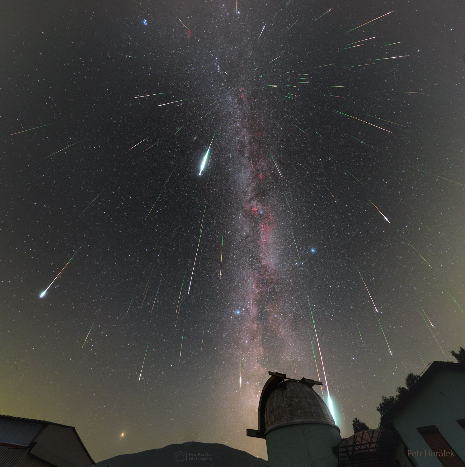Mulitple streaks cover a night sky filled with stars. An observtory dome is visible in the foreground. Please see the explanation for more detailed information.