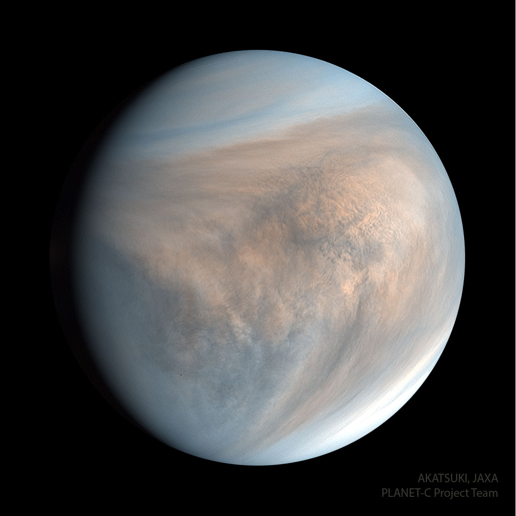 Planet Venus is pictured in ultraviolet light. The spherical planet appears circular in tan colors with hints of blue. Complex cloud patterns are evident. Please see the explanation for more detailed information.