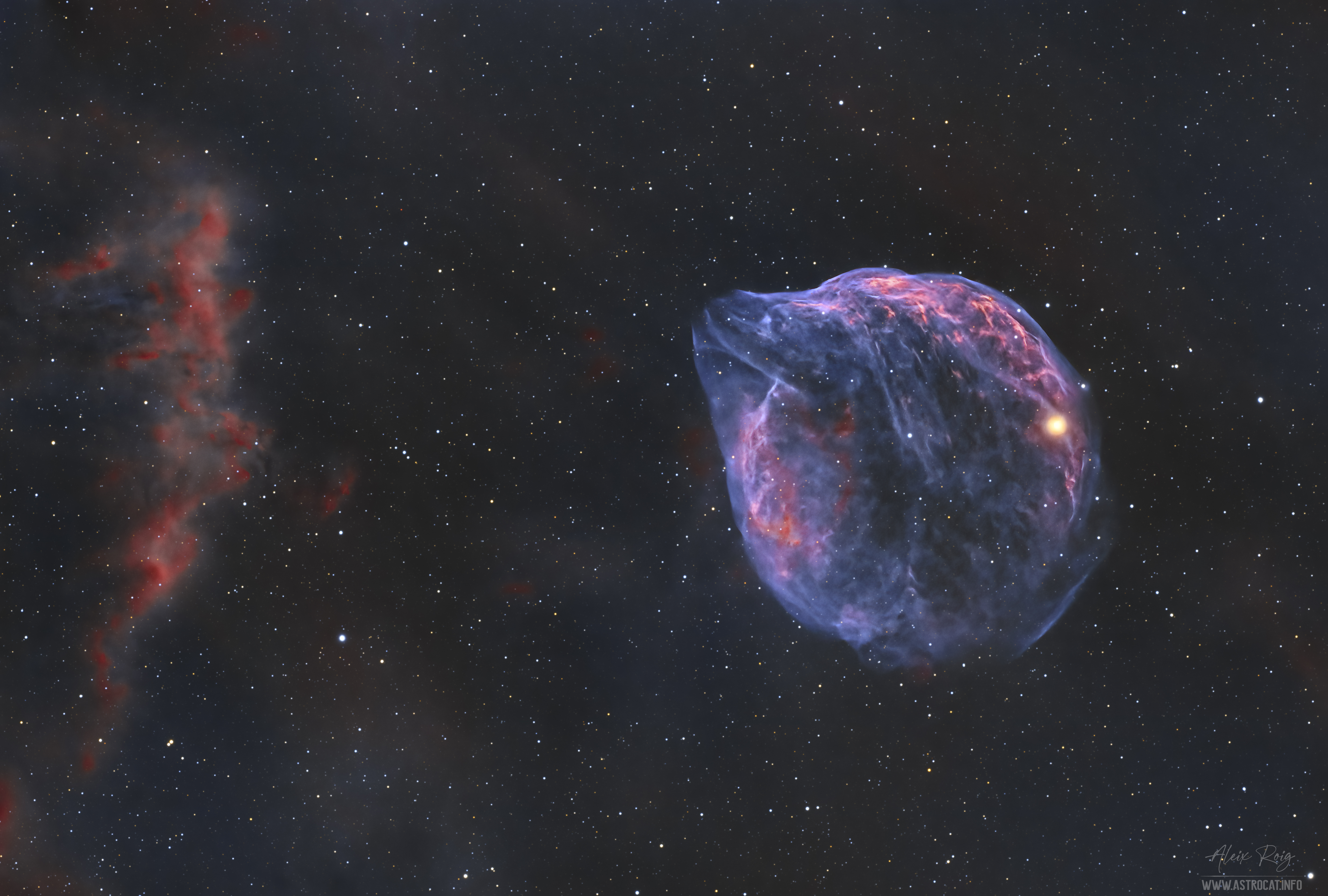 A star field is shown with ragged red clouds on the far left and a thin blue cloud with the outline similar to the head of a dolphin to the right. Please see the explanation for more detailed information.