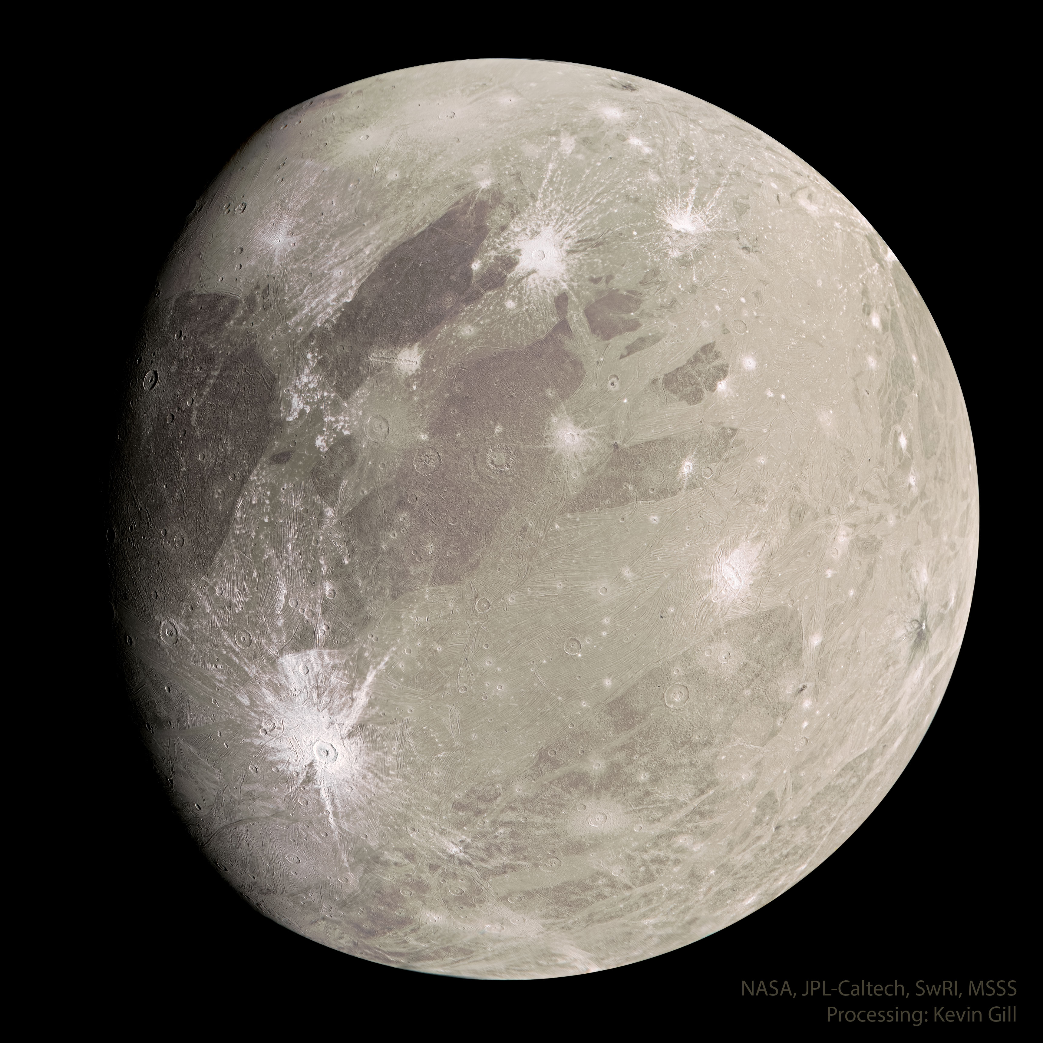 A tan sphere is shown with dark markings and a few light craters. The sphere is the largest known moon in the Solar System: Jupiter's moon Ganymede. Please see the explanation for more detailed information.