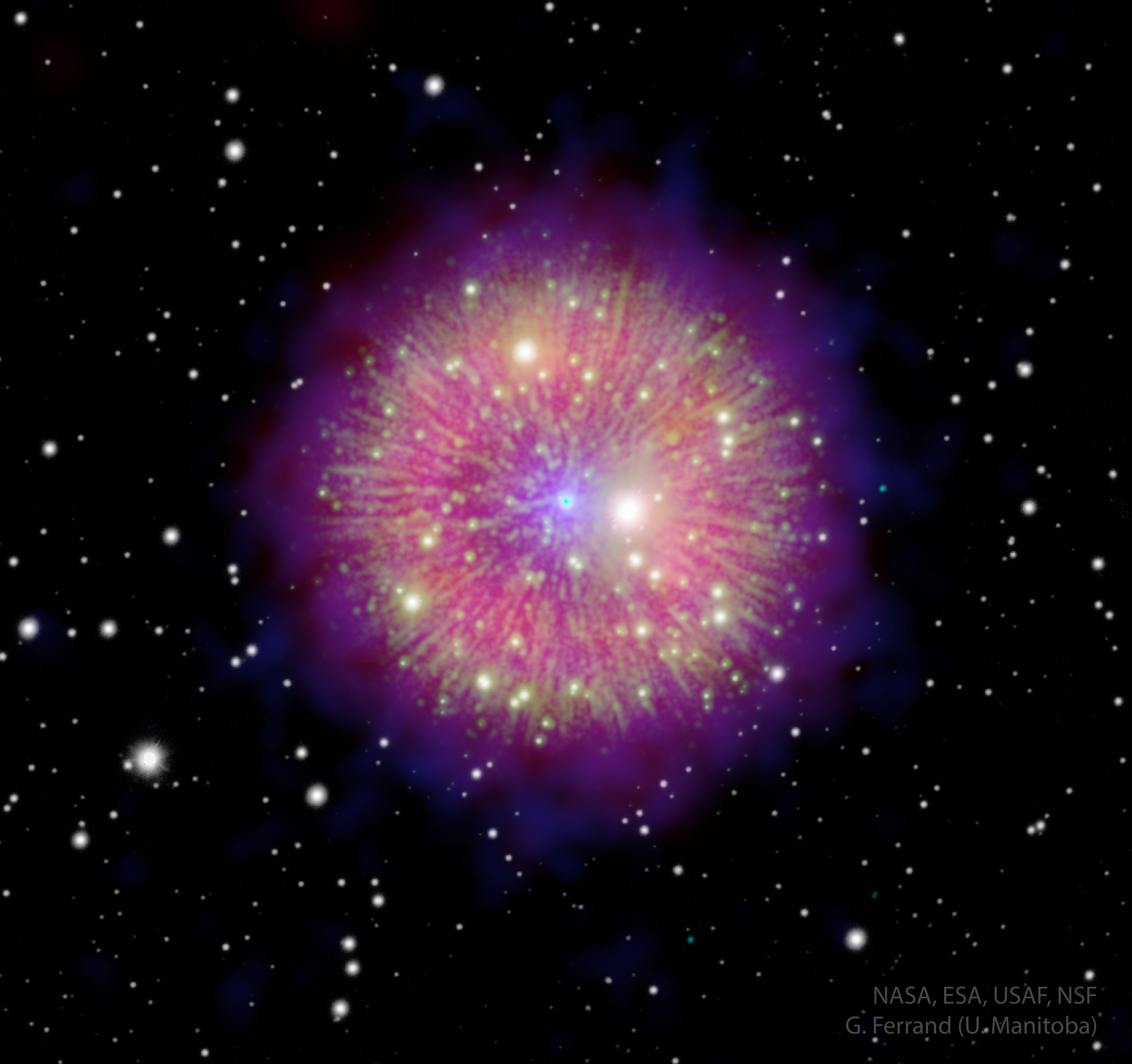 A nebula is shown that appears like a firework. Radial filaments connect a glowing halo to a star in the center that appears as a blue dot. Please see the explanation for more detailed information.