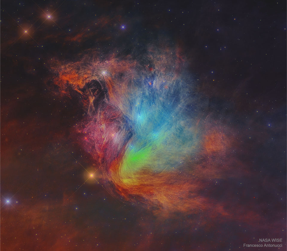 A famous Pleiades star cluster is shown but showing numerous parallel and curved filaments in different colors. The image is in several colors of infrared light. A rollover image shows the cluster in visible light with its familiar blue light. Please see the explanation for more detailed information.