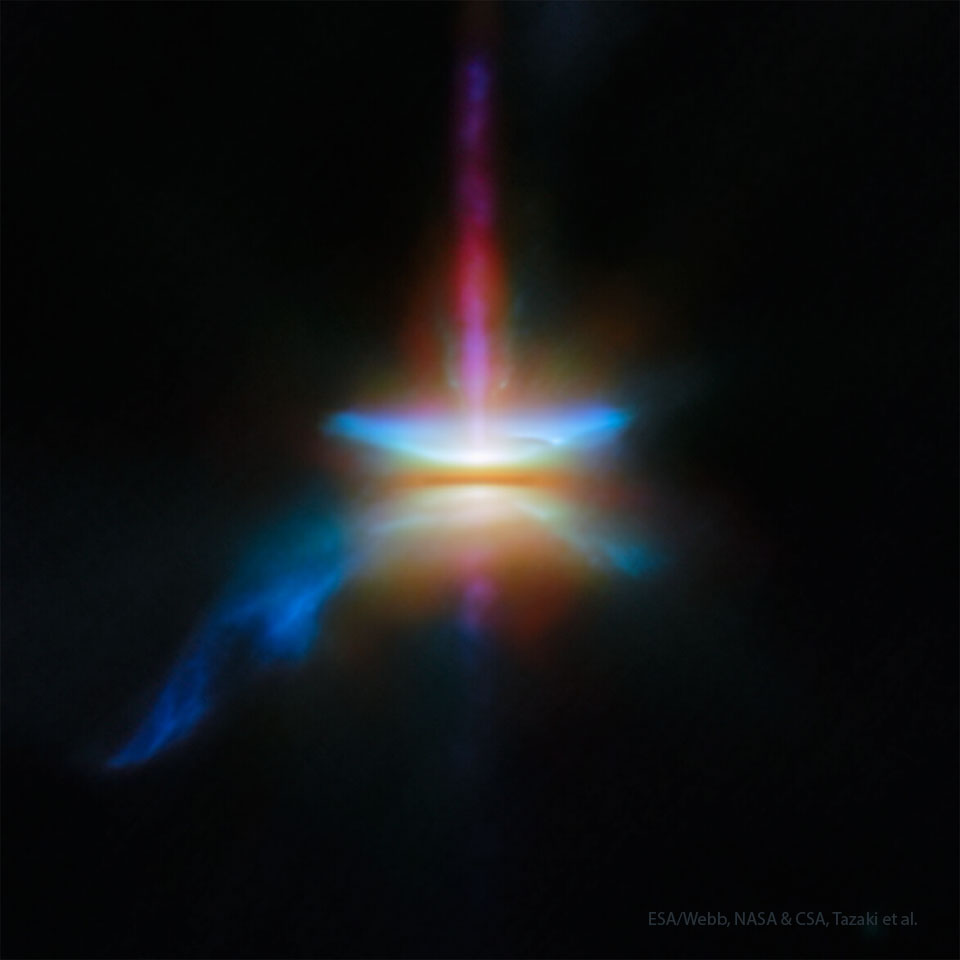A dark field has a single, colorful, blurry structure in its center. Red-colored jets extend out from the center toward the top and bottom of the frame. A dark disk covers the center. Blue outflows appear on both sides of the horizontal disk. To the lower left, a larger blue outflow extends. Please see the explanation for more detailed information.