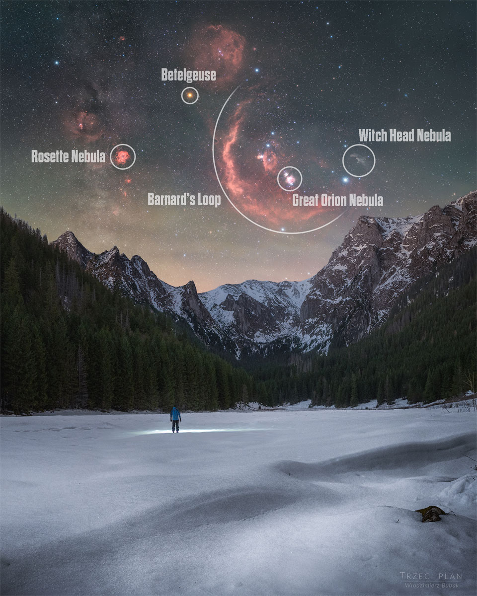 A person stands in the distance on a snowy landscape shining a flashlight on the ground. Trees and snow capped mountains are on the horizon. In the starry sky above, several iconic red nebulas are visible. Please see the explanation for more detailed information.