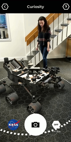 A short movie showing a person walking around a room with an augmented reality rover placed on the floor by using the mobile application Spacecraft AR.