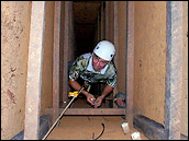 Photograph of a researcher at the bottom of a 10-meter deep soil sampling pit