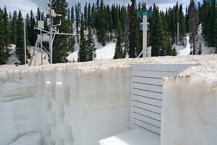 Photograph of a snow pit that reveals layers of dust in the late-season Colorado snowpack.
