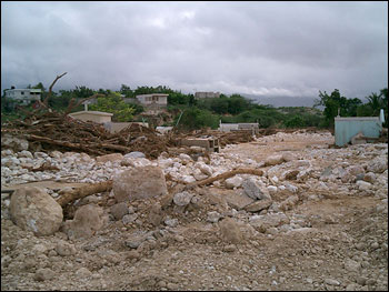 This photo shows a cemetery in Jimani that was almost completely overrun by gravel and debris deposited by the torrential flows of rainwater running down the northern flank of the Massif de la Salle. (Photo by Manual Santana courtesy USAID)