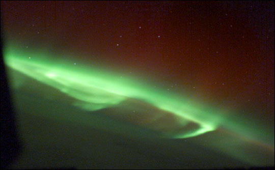 Photograph of broad swirls of aurora over Canada.
