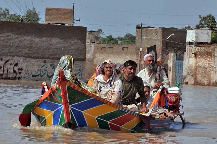Photograph of a family escaping the floods in northwestern Pakistan by boat.