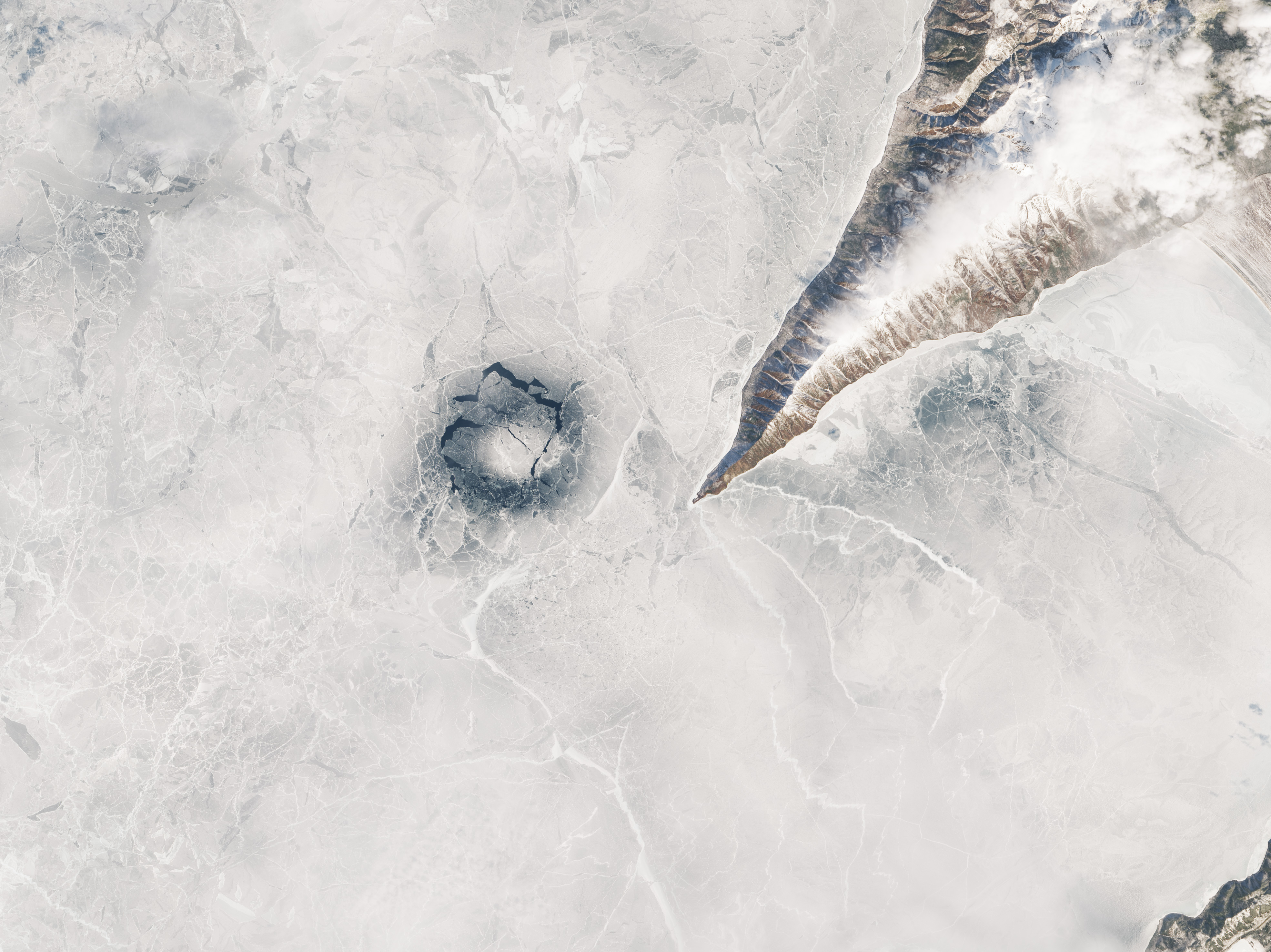 Anillo oscuro en el hielo del lago Baikal junto a una costa montañosa, imagen Landsat del 1 de abril de 2016