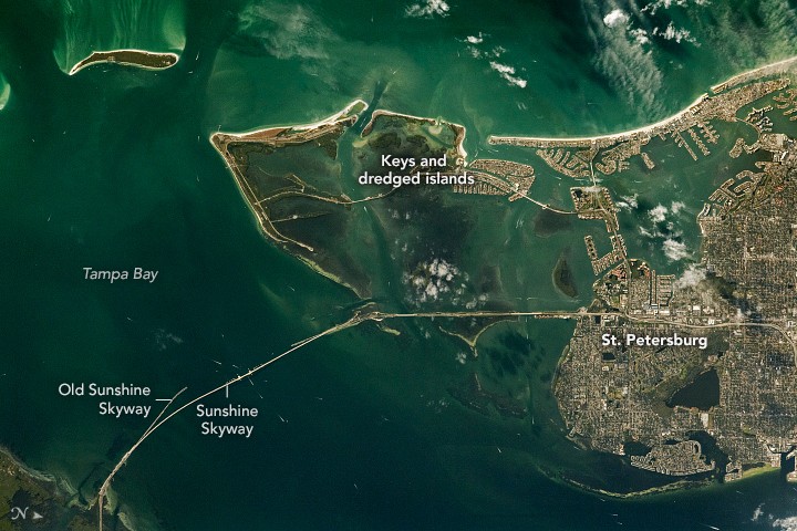 Astronaut photograph of Tampa Bay showing its bridges, piers and developed keys, including the Sunshine Skyway Bridge