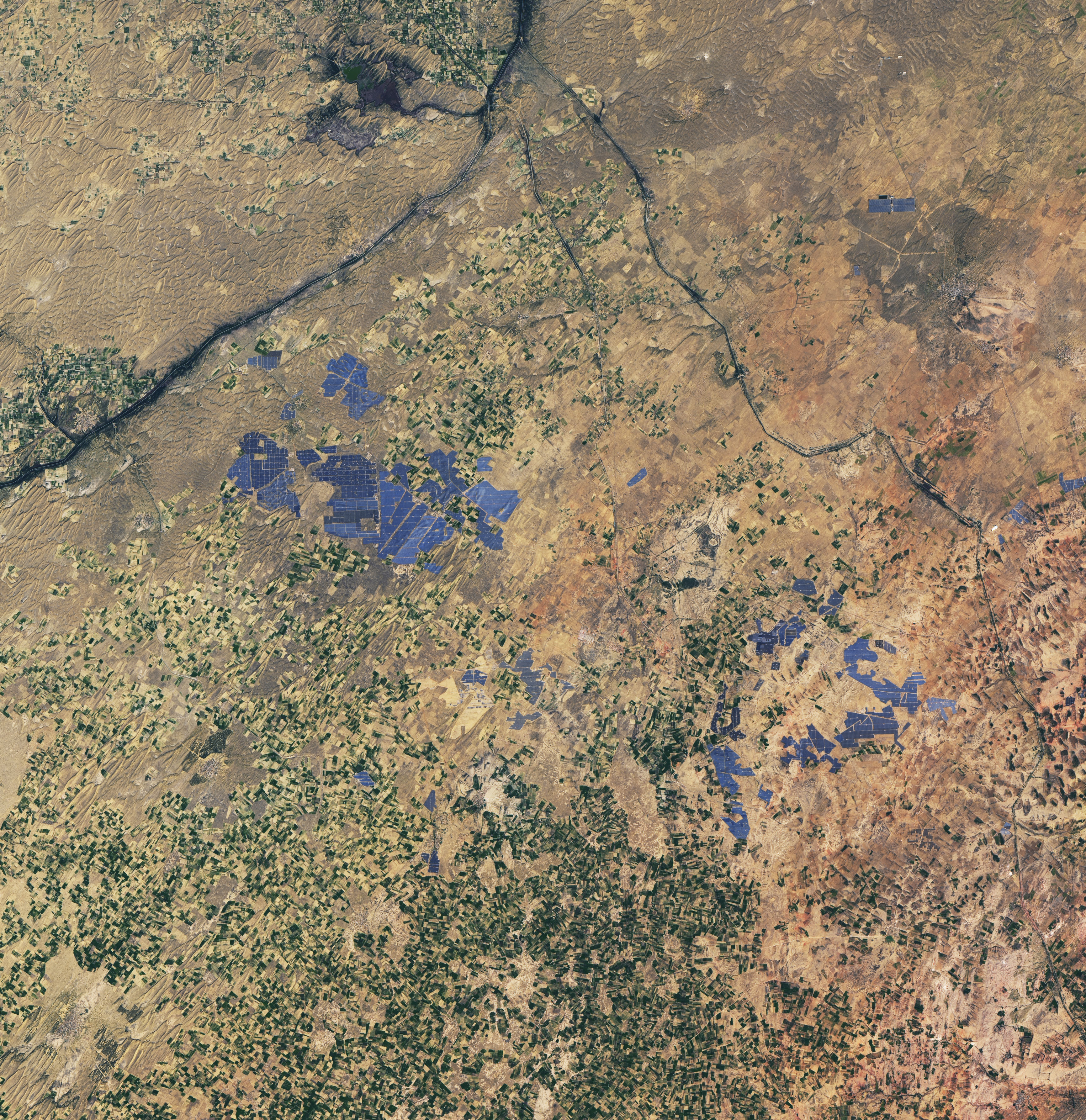 NASA Landsat 8 satellite image of Bhadla Solar Park in the Thar Desert of Rajasthan, India, showing millions of photovoltaic panels in a 22-square-mile array
