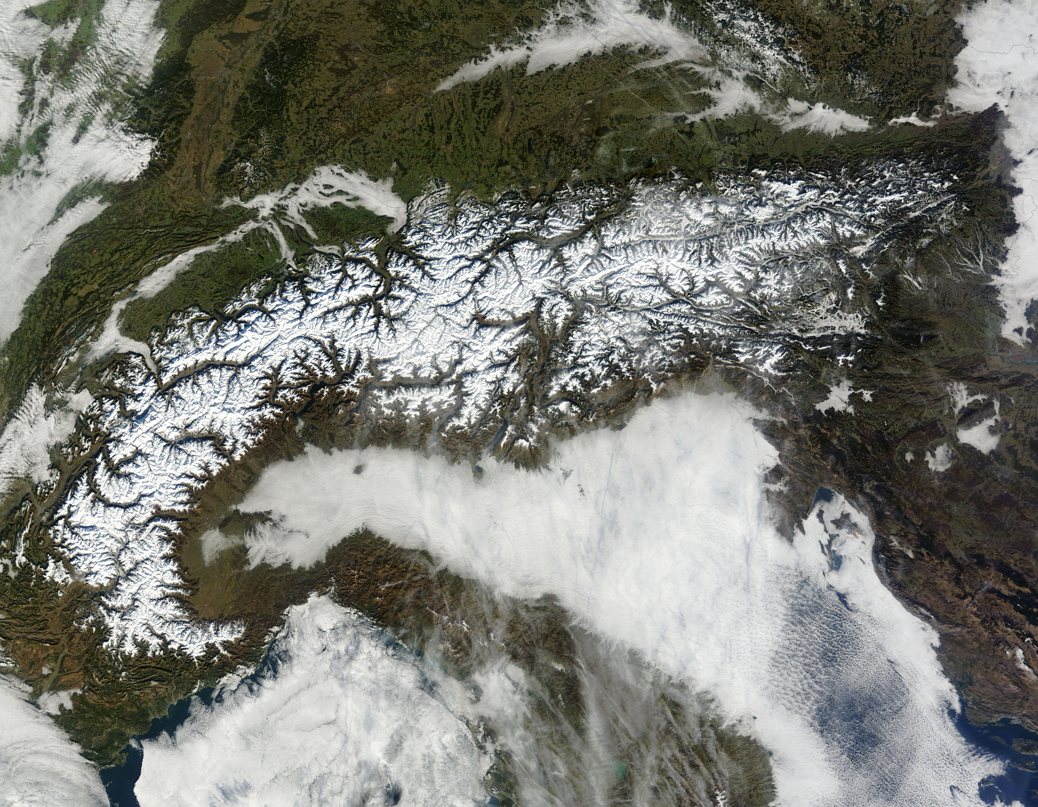 NASA Terra MODIS satellite image of the Alps showing snow-capped mountain ranges across France Switzerland Italy and Austria with Lake Geneva and the Mont Blanc massif visible