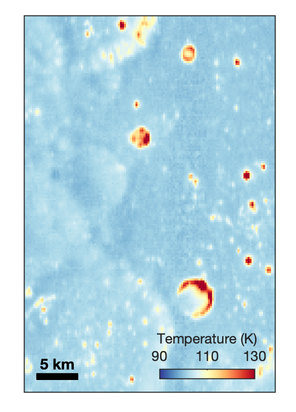 Animated temperature map that alternates between two images. A vertical strip through the center blinks on and off, revealing a dark blue circular area surrounding a small white spot near the middle. The pale blue map also contains scattered yellow, orange, and red spots and rings, including a large, curved red-and-yellow feature near the lower center. A 5-kilometer scale bar appears at lower left, and a color key ranges from 90 kelvin in dark blue to 130 kelvin in dark red.