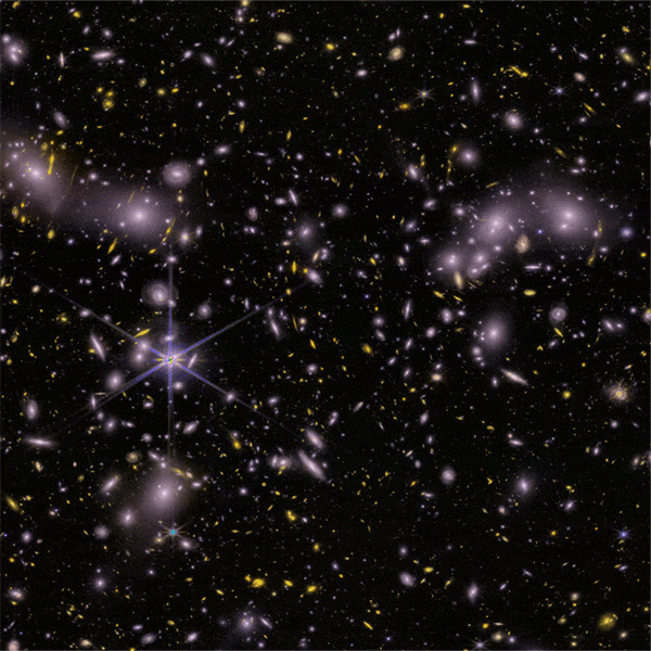 Animation showing the locations of young, low-mass, starburst galaxies around galaxy cluster Abell 2744.  White and yellow galaxies of various sizes and shapes appear against the blackness of space. Two bright stars in our own galaxy display prominent six-spike diffraction patterns with bluish rays, visible at center left and lower left. Then 20 white diamonds sweep across the image. One diamond enlarges to reveal an image of a young, low-mass, star-forming galaxy. It looks like a green oval against a red and green checked background. The enlarged image then shrinks back, and the diamonds sweep away. The sequence loops.