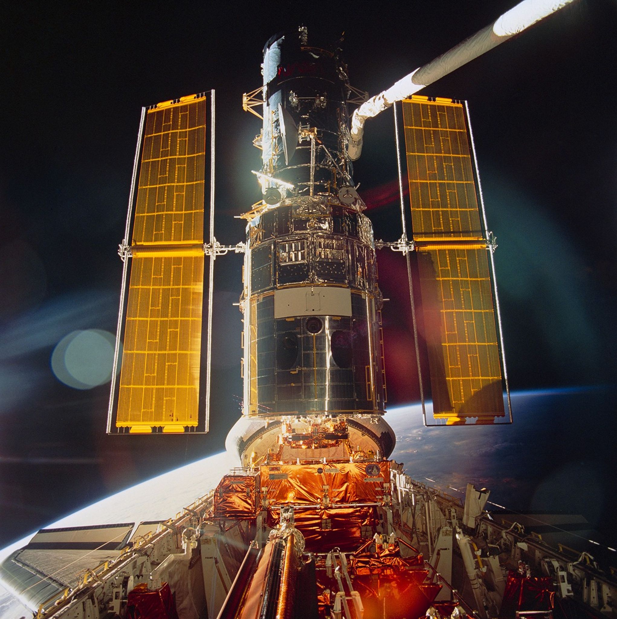 The space shuttle is shown in sunlight in orbit.