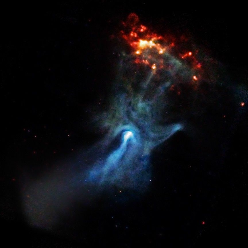 A supernova remnant rises like an ethereal blue hand across the center of the image. This blue hand-shaped nebula intersects a spotty red oval with dots of light. These both represent X-ray views of the nebula, with the highest energy X-rays shown in blue, and the lower energy in red.