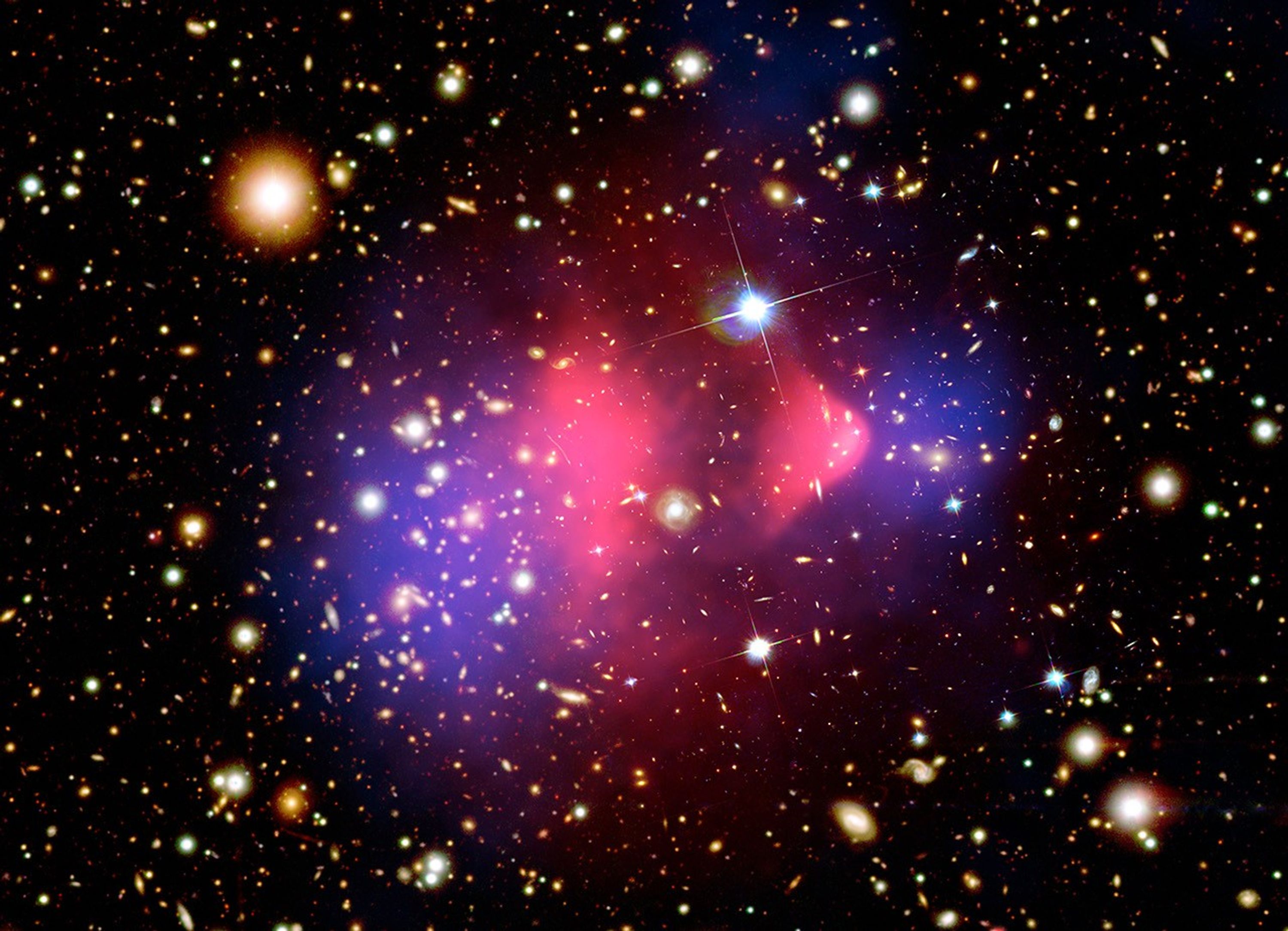 This image shows two colorful gas clouds, both with hot pink gas at the center and blue-purple gas around the edges, indicating the presence of dark matter after a galactic collision.