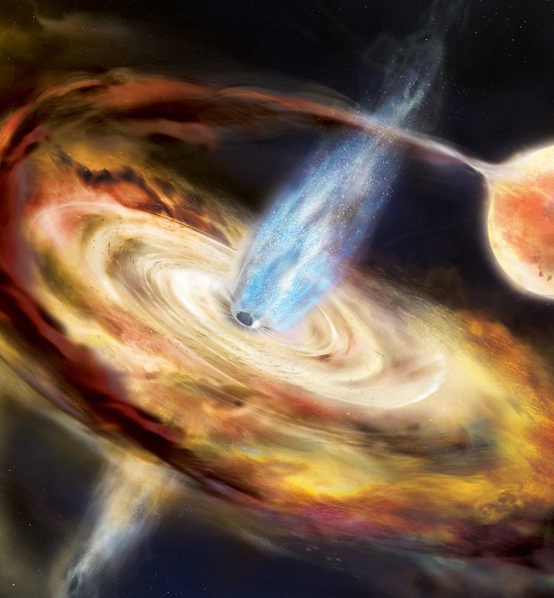 A large pancake-shaped disk of material swirls in toward a black hole at the center of the disk. An orange star enters the image on the right and behind the disk, but a stream of gas connects to the disk in a long, thin arc. A blue flame-shaped region rises above the disk, from near the black hole. A similar region is just visible protruding below the disk as well.