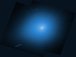 An image from NASA’s Hubble Space Telescope showing the interstellar comet 3I/ATLAS. The comet is a small white dot in the center of the image, with a light blue halo of light that takes up most of the image. Other stars are shown streaking across the image as diagonal blue-white lines.