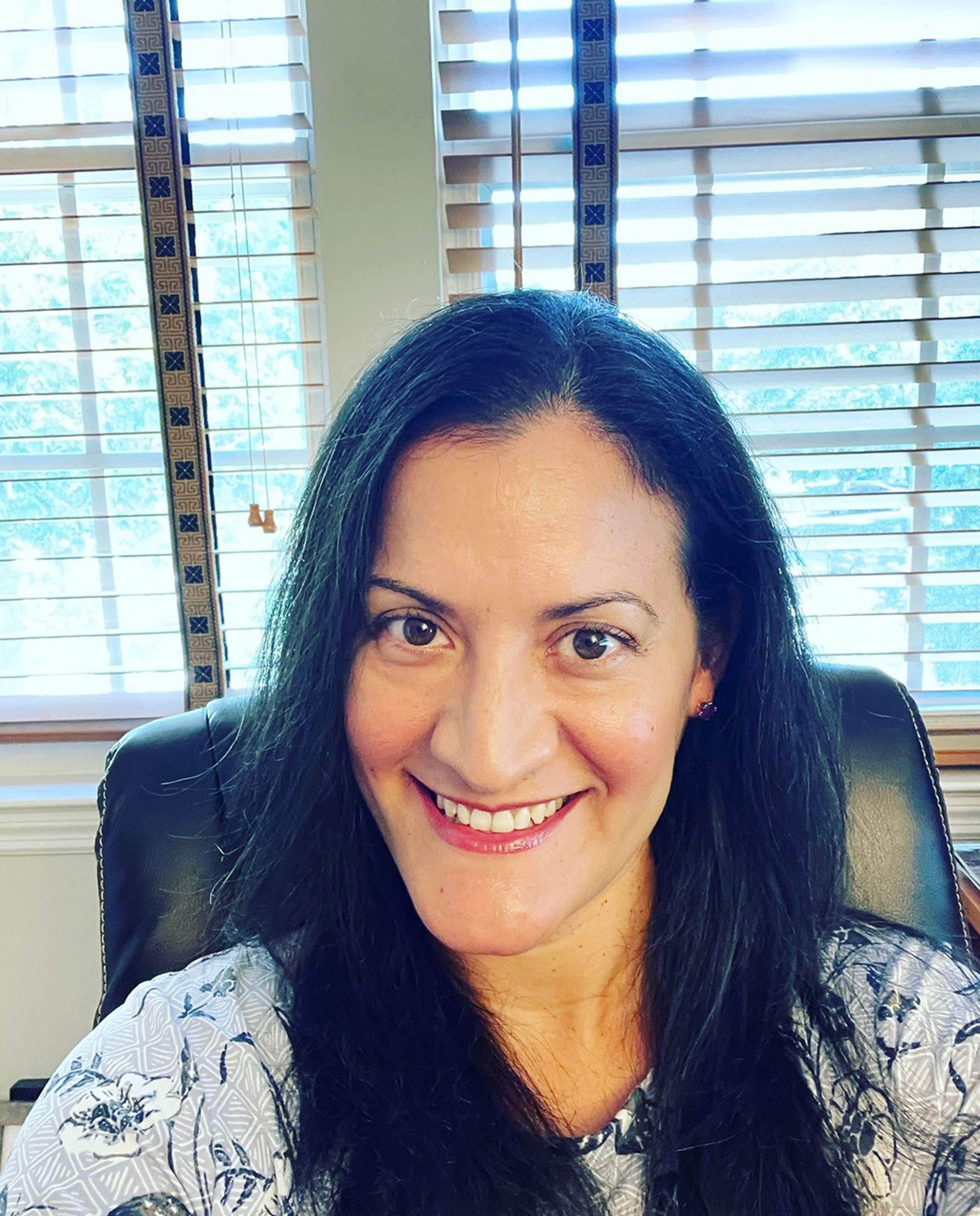 Portrail photo of a smiling woman with long dark hair