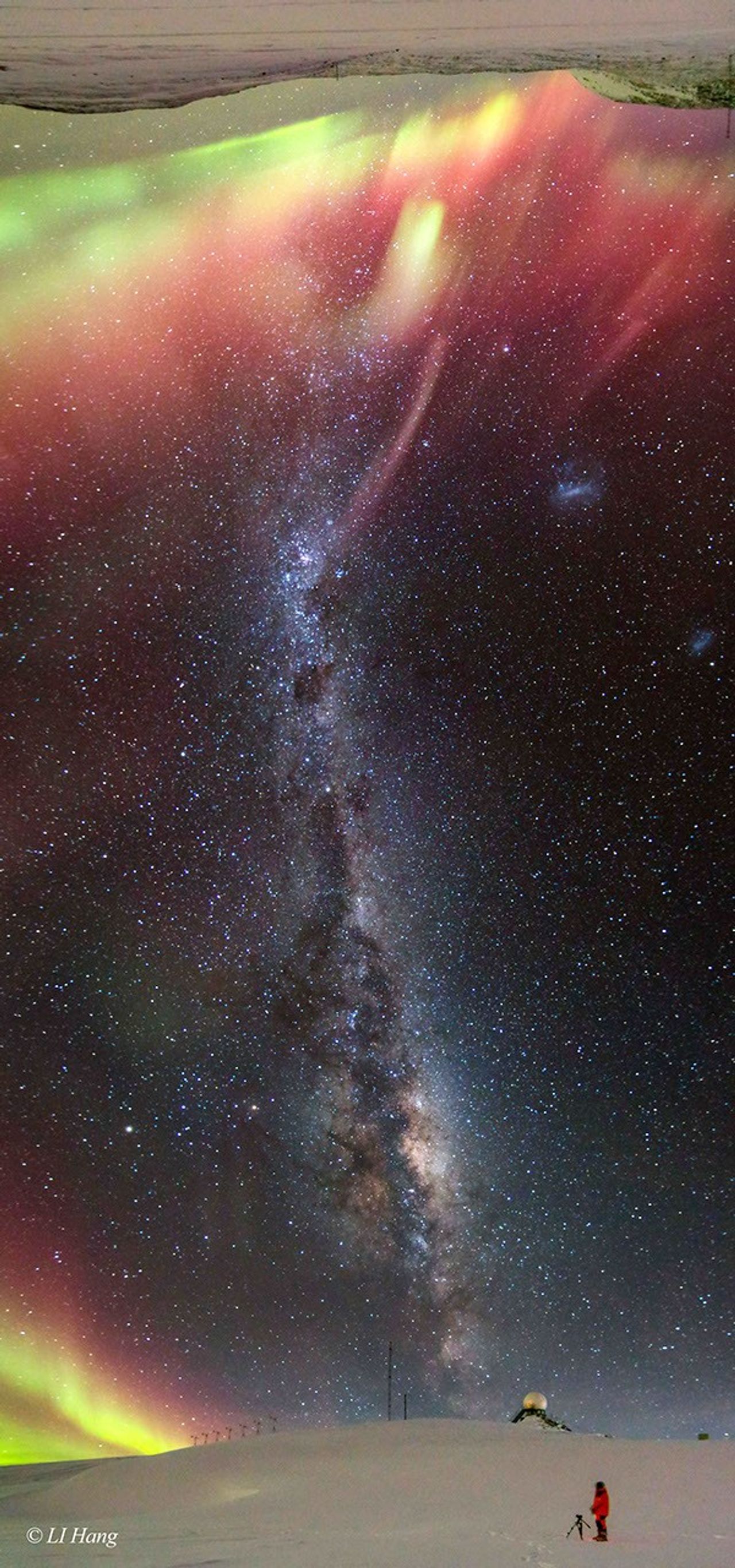 A long vertical image shows a band of the night sky from horizon at the bottom to the opposite horizon -- at the image top. A person stands on a snow covered landscape with the central band of the Milky Way running between horizons. Each ho