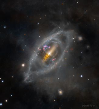 An unusual galaxy is shown that appears lens-like in overall shape yet has various rings of stars around the center. Please see the explanation for more detailed information.