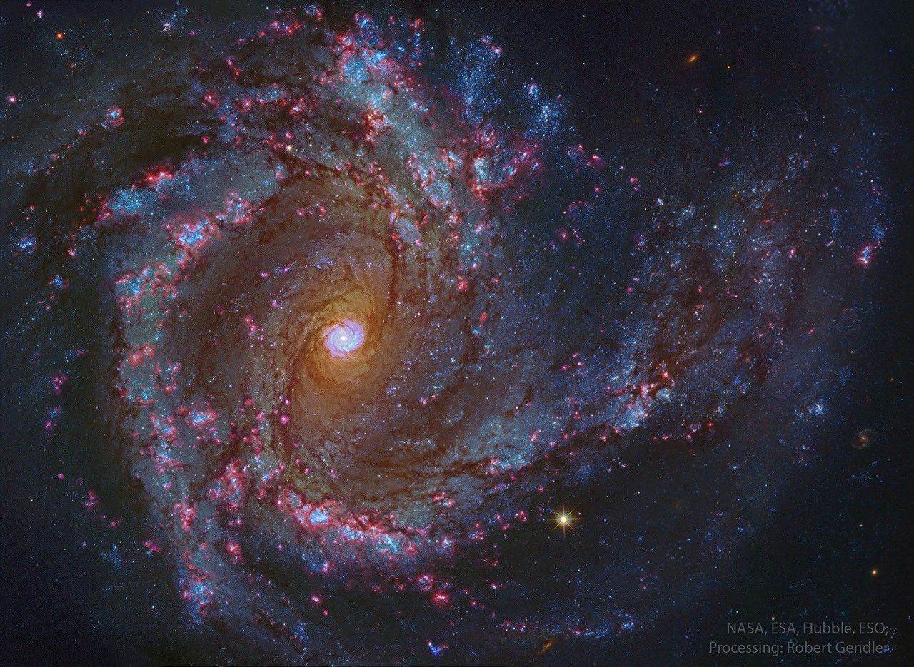 A sprawling spiral galaxy is shown in great detail. This galaxy has blue spiral arms and a bright center that itself seems to look like a spiral galaxy. Please see the explanation for more detailed information.