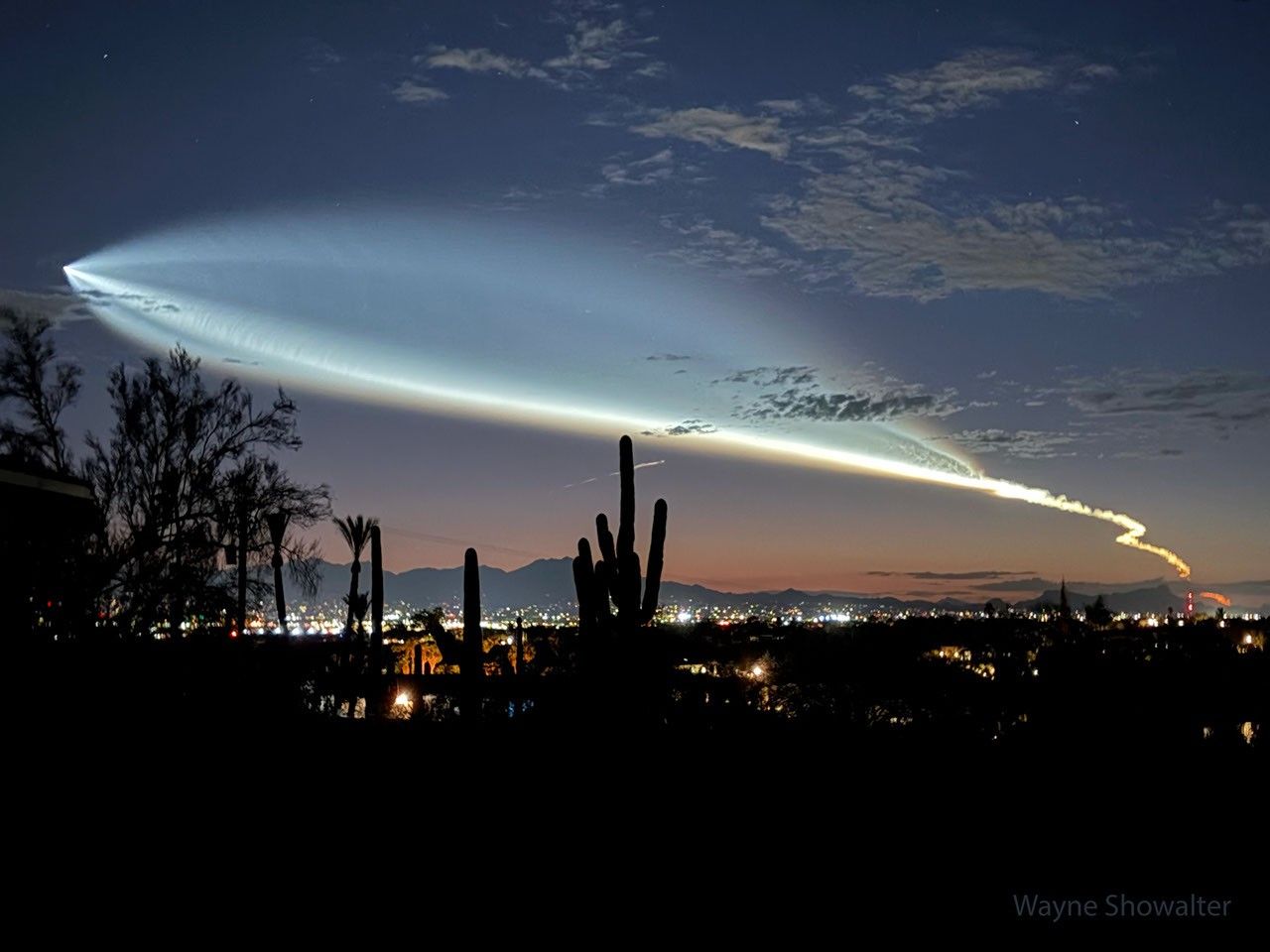 A horizon including the Tucson skyline and Saguaro cacti shows the sky just after sunset. Prominent in the sky are clouds oddly shaped like a fish -- but are the launch plume of a recently launched rocket from California. Please see the exp
