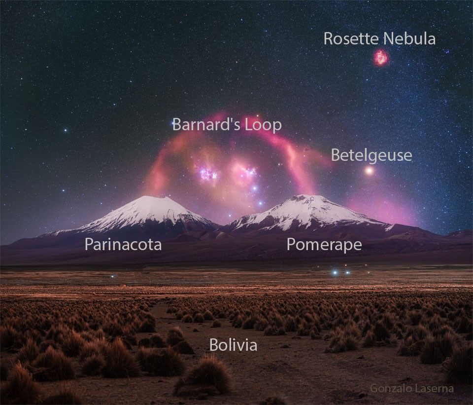 A pair of snow topped volcanoes are seen in the distance. A background starry sky is seen behind them, with a red filamentary nebula looping around that appears to connect the two tops of the volcanoes.