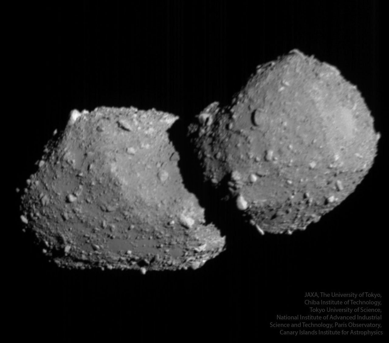 A large rocky object floats in dark space. The object is gray and has many small protrusions. Please see the explanation for more detailed information.