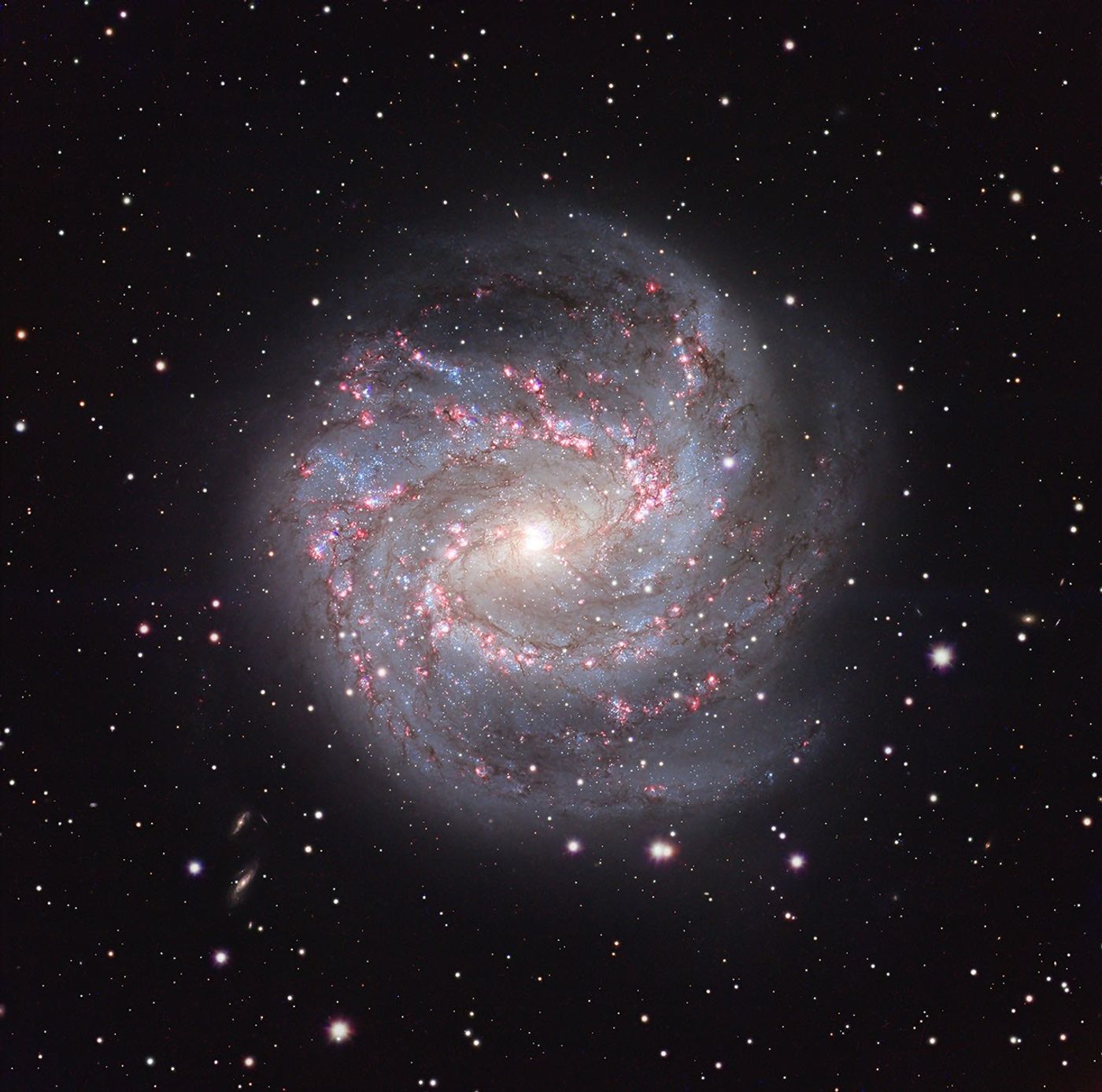A spiral galaxy is shown in front of a dark field of stars.