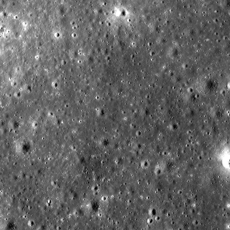 An image of the lunar surface speckled wth impressions (craters) of various small sizes.