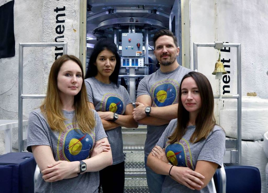 La tripulaci�n para la actual misi�n HERA de la NASA de pie frente al h�bitat en donde vivir�n y trabajar�n durante 45 d�as para ayudar a la agencia a estudiar los efectos del aislamiento, el confinamiento y las condiciones remotas durante la exploraci�n. De izquierda a derecha: Lauren Cornell, Monique Garc�a, Christopher Roberts y Madelyne Willis. Cr�ditos: NASA