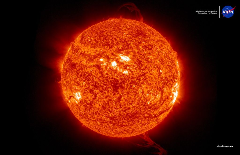 Imagen del Sol exhibiendo una ráfaga de actividad solar. El Sol aparece como una esfera de color naranja brillante contra el fondo negro del espacio, con varias erupciones solares visibles extendiéndose desde diferentes áreas de su superficie.