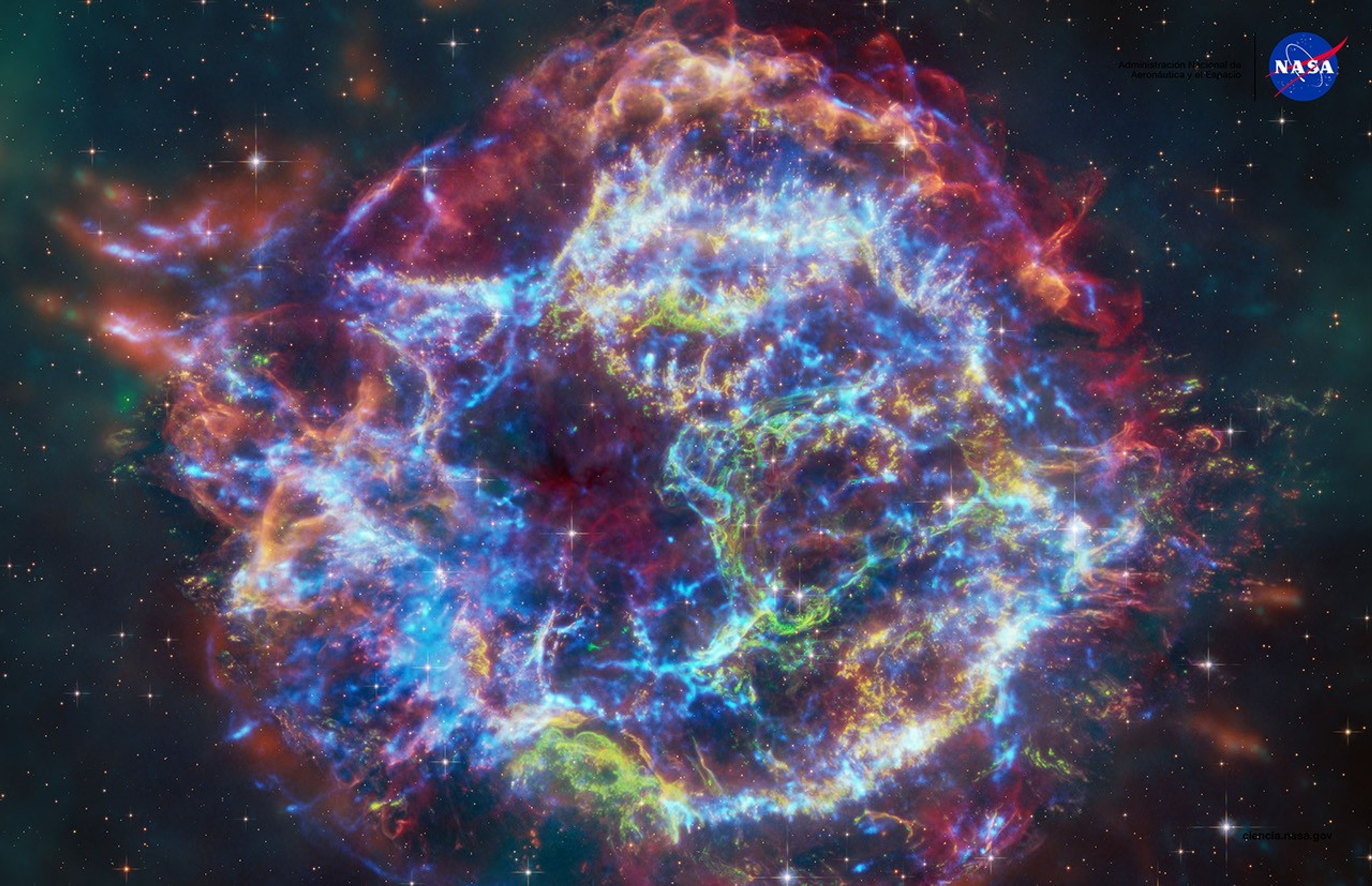 Una colorida imagen compuesta del remanente de supernova Casiopea A. Esta imagen contiene rayos X del observatorio Chandra (azul), datos en infrarrojo del telescopio espacial Webb (rojo, verde, azul) y datos ópticos del telescopio espacial Hubble (rojo y blanco). Las partes exteriores de la imagen también incluyen datos infrarrojos del telescopio espacial Spitzer de la NASA (rojo, verde y azul).