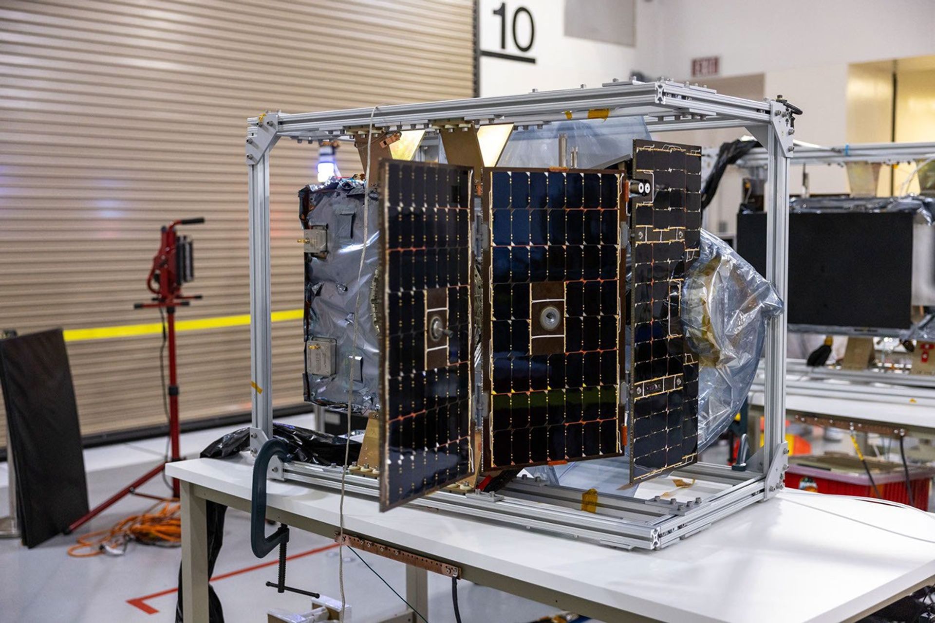 Equipos de trabajadores realizan pruebas adicionales con el despliegue de los paneles solares del Polarímetro para Unificar la Corona y la Heliosfera (PUNCH) de la NASA en el Centro de Operaciones Espaciales Astrotech situado en la Base de la Fuerza Espacial Vandenberg en California, el miércoles 22 de enero de 2025.