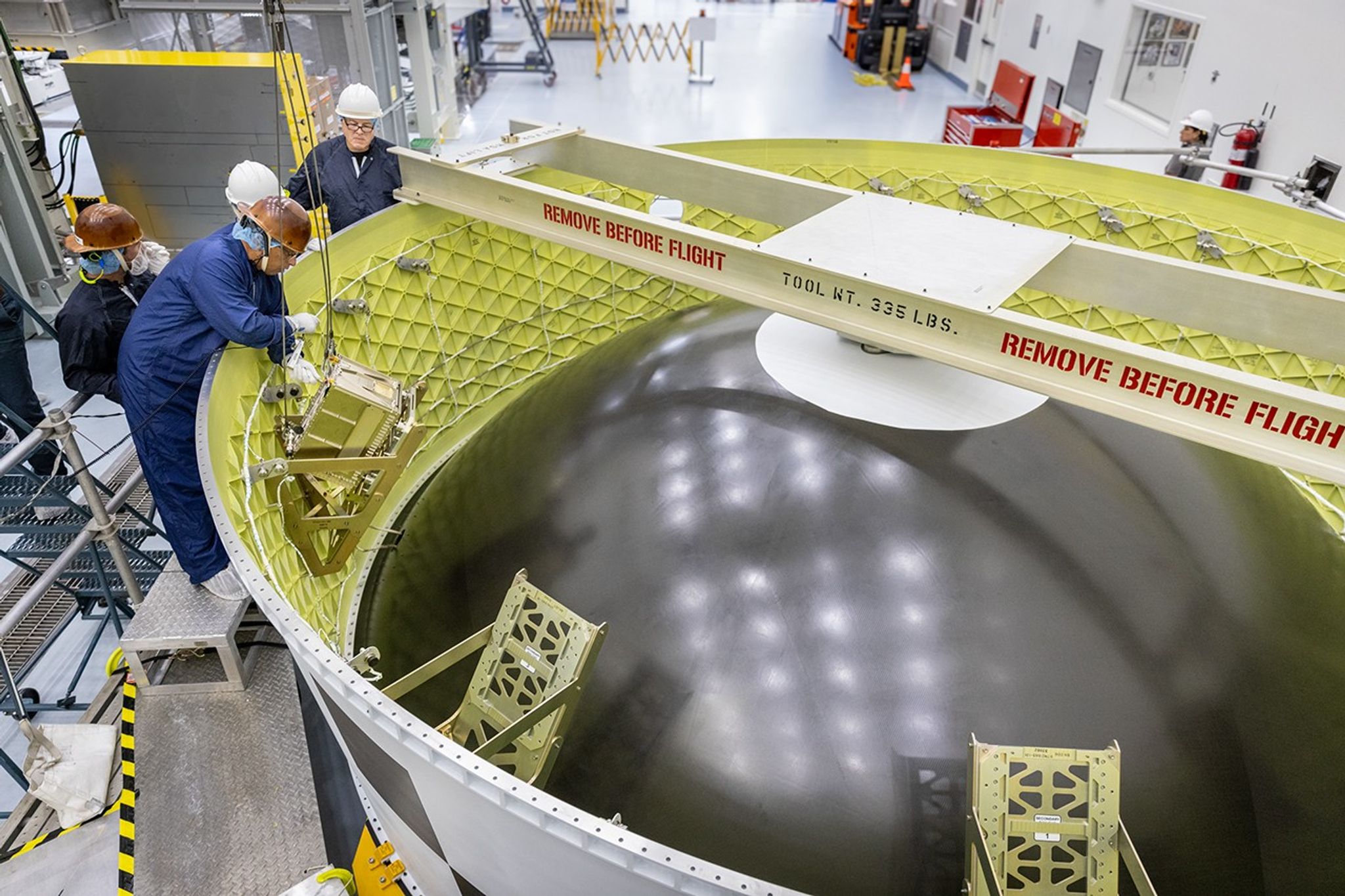 Técnicos instalan el K-Rad Cube de la KASA (Administración Aeroespacial de Corea del Sur) dentro del adaptador de la etapa de Orion en el interior de la Instalación de Procesamiento de Carga Útil Múltiple, el martes 2 de septiembre de 2025, en el Centro Espacial Kennedy de la NASA en Florida. El K-Rad Cube, del tamaño de una caja de zapatos, es uno de los CubeSat que se tienen programados para viajar a bordo del vuelo de prueba Artemis II de la NASA en 2026.