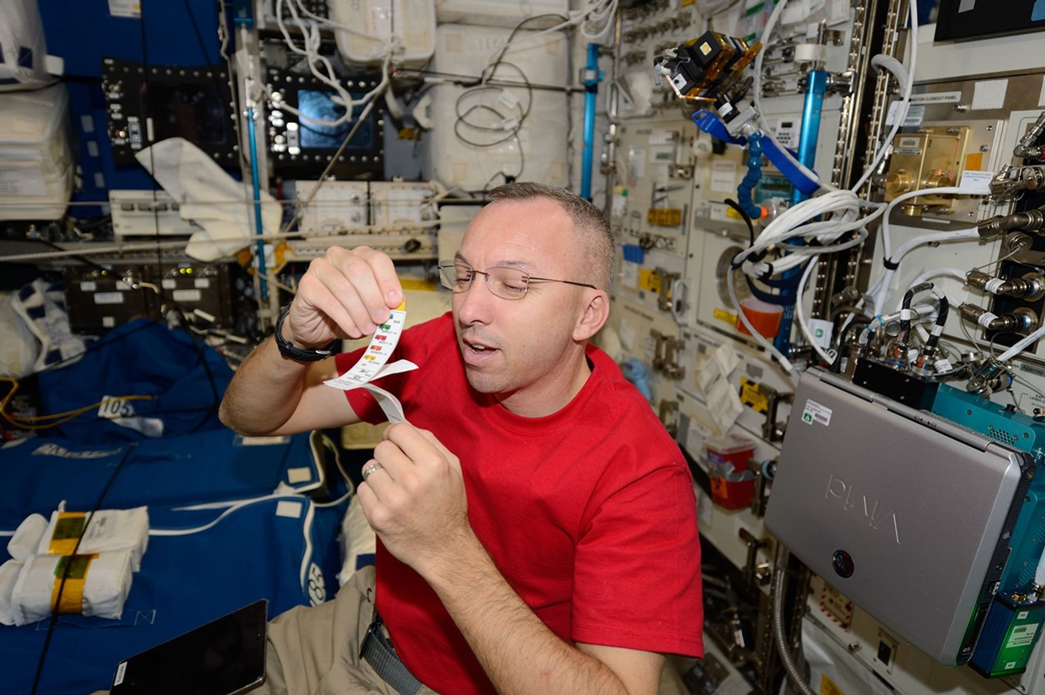 El astronauta de la NASA Randy Bresnik se prepara para recolectar una muestra de saliva seca a bordo de la Estación Espacial Internacional. Este proceso, el cual ayudará a los científicos a investigar cómo el sistema inmunitario se ve afectado por los vuelos espaciales y que será parte de la misión Artemis II, consiste en absorber la saliva con un papel especial que se almacena en libretas pequeñas.