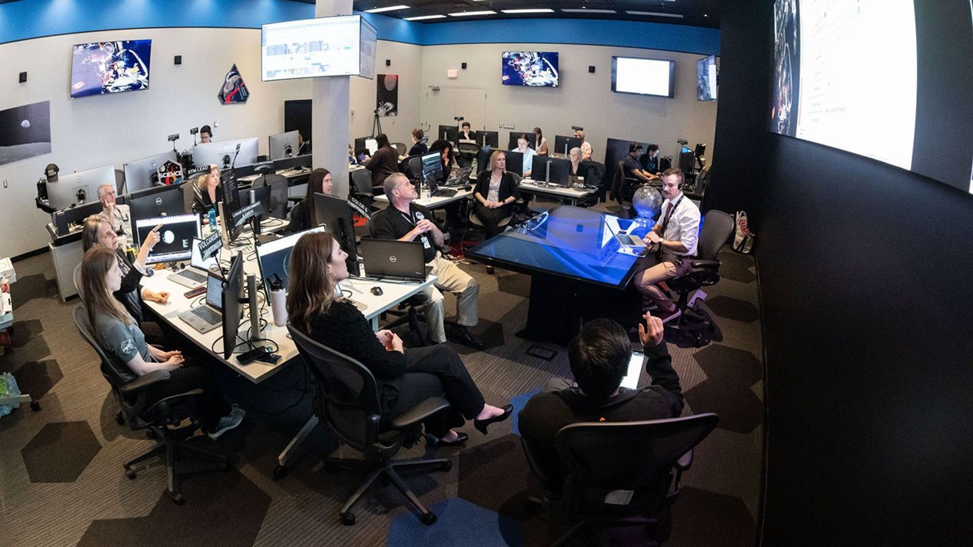 En esta imagen del 3 de abril de 2026, se muestra al equipo de expertos en ciencia lunar de Artemis II trabajando en la Sala de Evaluación Científica del Centro de Control de Misión del Centro Espacial Johnson de la NASA en Houston. En la imagen, el equipo está elaborando un plan de observaciones científicas para la tripulación de Artemis II, la cual se dirigía hacia la Luna a bordo de la nave Orion.