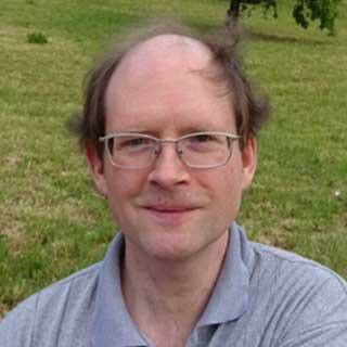 Selfie of a man standing on a green grass field