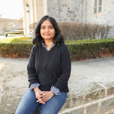 Portrait photo of a woman sitting in front of a building