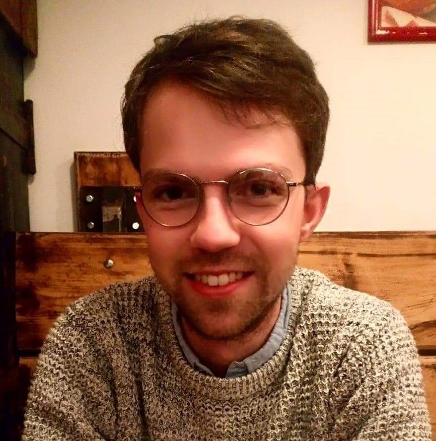 Photo of a smiling man wearing glasses