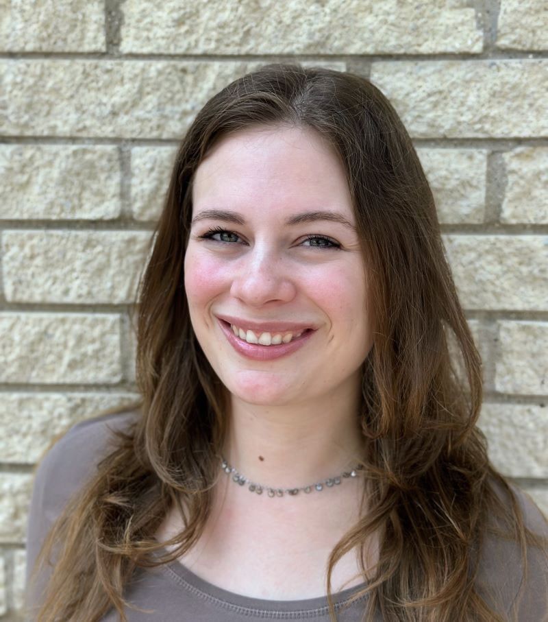 Portrait photo of a smiling young woman with long brown hair